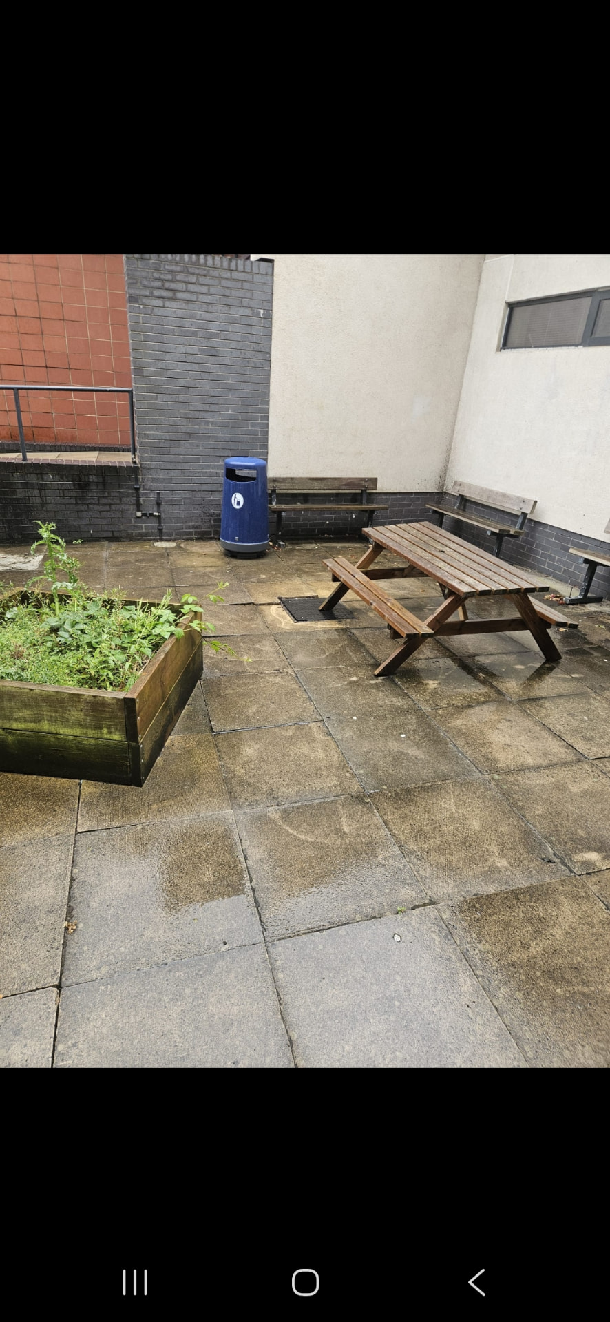 Stained communal courtyard paving before pressure washing