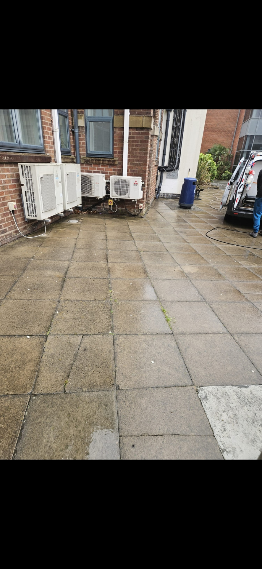 Dirty paved commercial service yard before cleaning