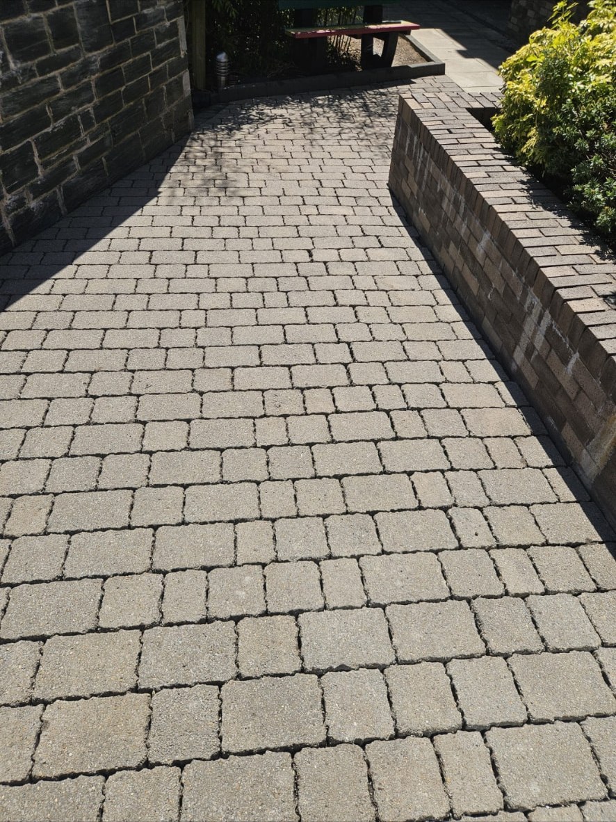 The same paved passage cleaned back to pale, even block paving